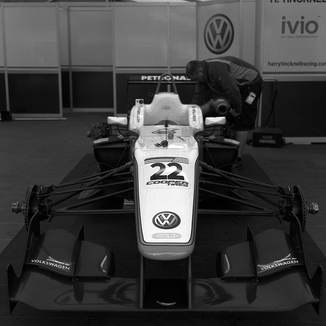 A black and white photograph of a Formula 3 car in the paddock at Donington Park