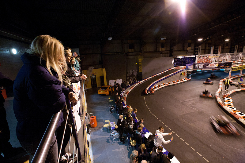 Karts racing around the track while spectators watch on