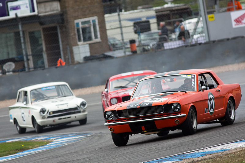 Mustangs and a Lotus Cortina race into Redgate at Donington.