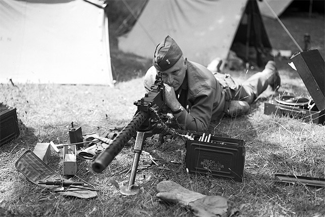 Soldier with machine gun in 1940s clothing.